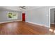 Spacious living room with hardwood floors, neutral paint, and a view of the red front door at 134 Nelson St, Durham, NC 27707