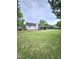 Spacious backyard showcasing a covered patio, chimney, and well-manicured lawn at 1360 Honeycutt Rd, Willow Springs, NC 27592