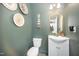 Stylish powder room featuring a modern vanity, decorative wall art, and a sleek toilet for a chic design at 1515 Millrock Trl, Wendell, NC 27591