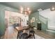 Open-concept dining area with stylish table set, chandelier, and views into modern kitchen and staircase at 1515 Millrock Trl, Wendell, NC 27591