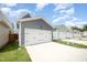 Row of garages with neutral siding and white doors along a paved driveway at 1515 Millrock Trl, Wendell, NC 27591