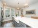 Spacious kitchen island with seating, a white farmhouse sink, stainless steel appliances, and stylish pendant lighting at 1515 Millrock Trl, Wendell, NC 27591