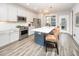 Bright kitchen featuring white cabinets, stainless steel appliances, a large island, and stylish barstool seating at 1515 Millrock Trl, Wendell, NC 27591