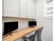 Comfortable home office with a built-in desk, upper cabinets, and a bright window providing a functional workspace at 1515 Millrock Trl, Wendell, NC 27591