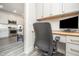 Office area with built-in desk, cabinets, and modern chair, conveniently located near the kitchen for functionality at 1515 Millrock Trl, Wendell, NC 27591