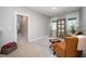 Inviting sitting area with plush leather chairs, ottoman, mirror, and soft carpet creates a cozy and stylish retreat at 1515 Millrock Trl, Wendell, NC 27591