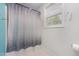 Bathroom with neutral shower curtain, window, and tile flooring at 18 Hunter Fox Trl, Angier, NC 27501