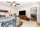 Bedroom featuring a large TV, wooden dresser, and a comfortable sitting area at 18 Hunter Fox Trl, Angier, NC 27501