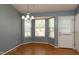 Cozy dining area featuring a bay window, chandelier lighting, and an entrance door at 200 Steeple Rd, Holly Springs, NC 27540