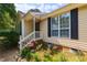 Welcoming home exterior with black shutters and a beautiful, well-maintained yard with flowering plants and walkway at 200 Steeple Rd, Holly Springs, NC 27540