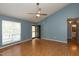 Spacious living room with hardwood floors, a fan, and a door to the backyard for seamless indoor-outdoor living at 200 Steeple Rd, Holly Springs, NC 27540