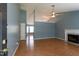 This open-concept living room features light blue walls, hardwood floors, and a beautiful fireplace with a marble hearth at 200 Steeple Rd, Holly Springs, NC 27540