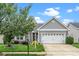 Charming home featuring a two-car garage, stone accents, manicured lawn, and mature landscaping, offering great curb appeal at 2033 Buck Corner Ln, Fuquay Varina, NC 27526