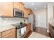 Modern kitchen featuring stainless steel appliances, granite countertops, and wood cabinetry at 2033 Buck Corner Ln, Fuquay Varina, NC 27526