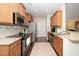 Well-lit kitchen boasts stainless steel appliances, wood cabinets, and granite countertops at 2033 Buck Corner Ln, Fuquay Varina, NC 27526