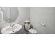 Modern half bathroom featuring a stylish round mirror and pristine white fixtures at 209 White Farm Dr, Wendell, NC 27591