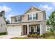 Charming two-story home with a two-car garage and inviting front porch, with fresh landscaping at 209 White Farm Dr, Wendell, NC 27591