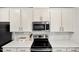 Modern kitchen with white cabinets, stainless steel appliances, and quartz countertops at 209 White Farm Dr, Wendell, NC 27591