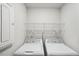 Functional laundry room features white appliances and overhead shelving, optimizing storage space at 209 White Farm Dr, Wendell, NC 27591