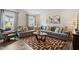 Spacious living room featuring a large gray sectional sofa, area rug, and plenty of natural light at 209 White Farm Dr, Wendell, NC 27591