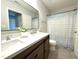 Bright bathroom featuring a dual sink vanity with modern fixtures and a framed mirror at 2107 Freeport Dr, Cary, NC 27519