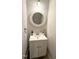 Bright half bath with white vanity, modern round mirror, faucet, and decor at 2107 Freeport Dr, Cary, NC 27519