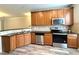Stylish kitchen with stainless steel appliances, black countertops, tile backsplash and wood cabinets at 2107 Freeport Dr, Cary, NC 27519