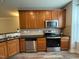 Traditional kitchen design with wooden cabinets, stainless steel appliances, and stone countertops at 2107 Freeport Dr, Cary, NC 27519