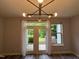 Spacious living room with hardwood floors, modern lighting and French doors leading to the yard at 2107 Freeport Dr, Cary, NC 27519