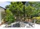 Outdoor patio area with black metal chairs, beautiful patterned tile, and lush landscaping offering a relaxing retreat at 2190 Keith Hills Rd, Lillington, NC 27546