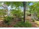Expansive backyard with lush greenery, mature trees, and a charming guest house offers a private and serene retreat at 2190 Keith Hills Rd, Lillington, NC 27546