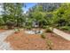 Beautiful backyard with a stone pathway leading to a cozy seating area with benches, surrounded by lush greenery at 2190 Keith Hills Rd, Lillington, NC 27546