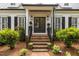 Close-up of the front entrance with brick steps, double doors, and decorative plants at 2190 Keith Hills Rd, Lillington, NC 27546