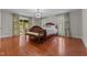 Main bedroom with wood floors, light-filled windows, and a classic wood bed frame at 2190 Keith Hills Rd, Lillington, NC 27546