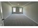 Spacious bedroom with plush carpet, tray ceiling, and natural light from the windows at 239 Paramount Dr, Smithfield, NC 27577