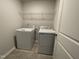 Well-equipped laundry room features tile flooring, washer, dryer, and wire shelving at 239 Paramount Dr, Smithfield, NC 27577
