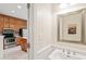 Elegant half-bath with a decorative mirror, faucet, and partial view of the adjacent kitchen at 240 Standish Dr, Chapel Hill, NC 27517