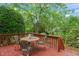 A wooden deck features a dining table and chairs with lush landscaping and mature trees at 240 Standish Dr, Chapel Hill, NC 27517