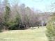 Playground with swings and a slide in a grassy common area with mature trees at 240 Standish Dr, Chapel Hill, NC 27517