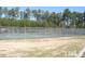 Outdoor tennis court surrounded by a tall fence and lush green trees at 240 Standish Dr, Chapel Hill, NC 27517