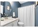 Stylish bathroom with a white vanity, marble countertop, round mirror, and white shower curtain at 2521 Georgianna Dr, Wake Forest, NC 27587