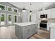 Bright, open kitchen with a gray island, modern appliances, and lots of natural light through many windows and a door at 2921 Wall Store Rd, Garner, NC 27529