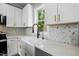 Close up on kitchen featuring white cabinets, stainless steel appliances, white countertops, and a modern faucet at 2921 Wall Store Rd, Garner, NC 27529