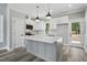 Modern kitchen with gray island, white cabinetry, and updated appliances at 2921 Wall Store Rd, Garner, NC 27529