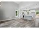 Open concept living room with vaulted ceiling and vinyl plank flooring next to a gray and white kitchen at 2921 Wall Store Rd, Garner, NC 27529