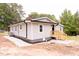 Side view of the house showing the gray siding, white trim, and new gravel landscaping at 3030 Forrester St, Durham, NC 27704