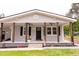 Charming home with a covered front porch featuring wooden pillars, ceiling fans, and freshly planted flowers at 3030 Forrester St, Durham, NC 27704