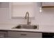 Close-up of the updated kitchen sink and faucet featuring marble countertops and a white tiled backsplash at 3030 Forrester St, Durham, NC 27704
