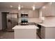 Well-lit kitchen with gray cabinets, marble countertops, stainless steel appliances, and an island at 3030 Forrester St, Durham, NC 27704