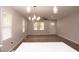 Spacious living room with light gray walls, dark gray laminate floors, and modern lighting fixtures at 3030 Forrester St, Durham, NC 27704